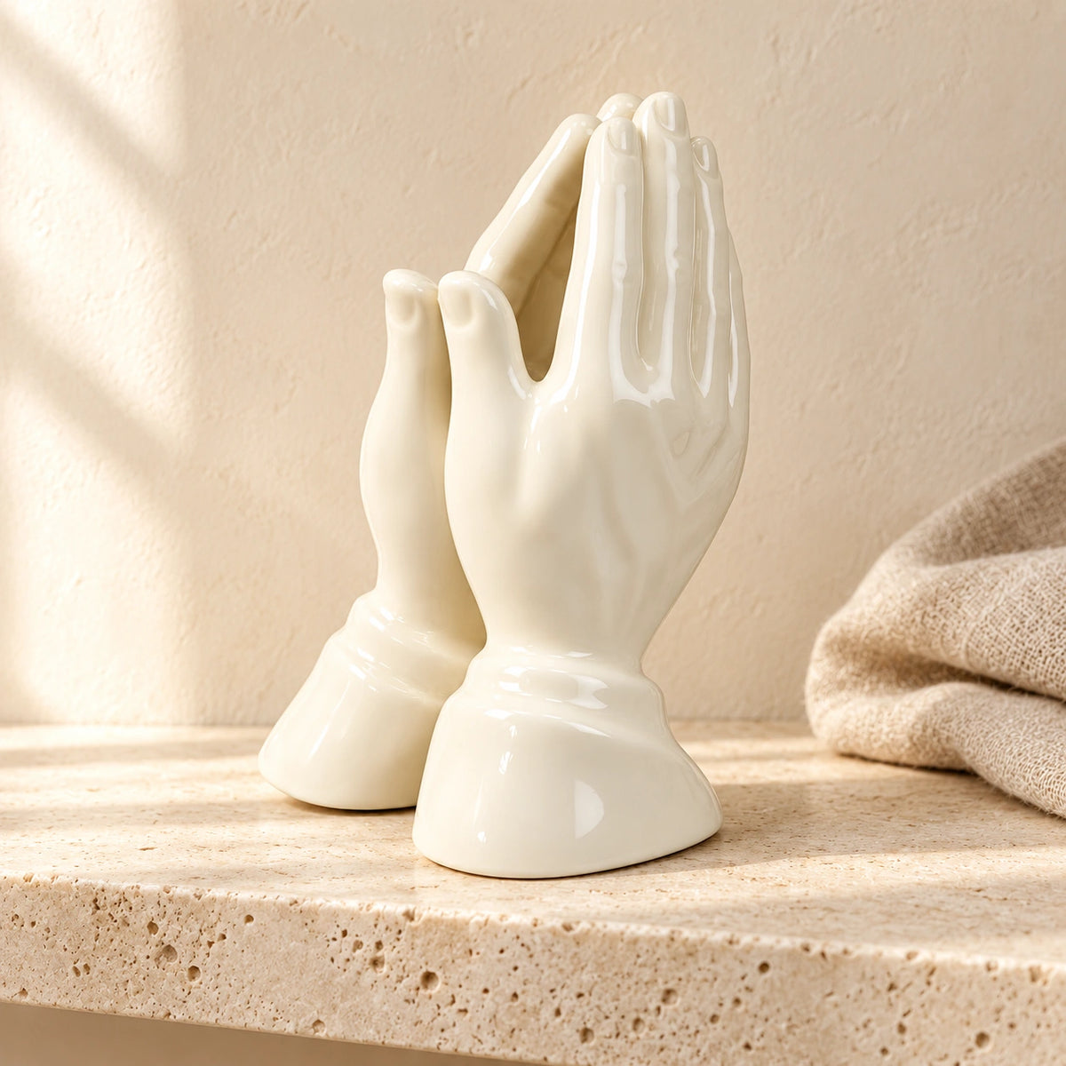 Porcelain Praying Hands Statue – 16.5cm styled on pale stone with linen