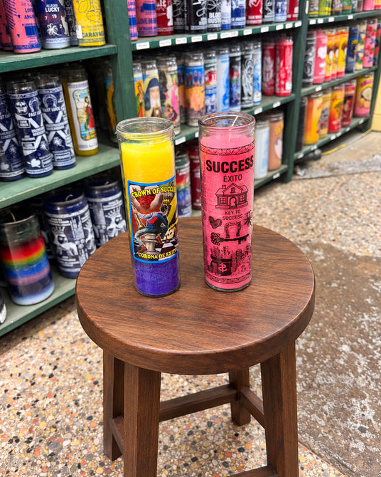 Crown of Success dressed candle and plain pink Success prayer candle in the Brixton shop; digitally replaced wooden display stand.