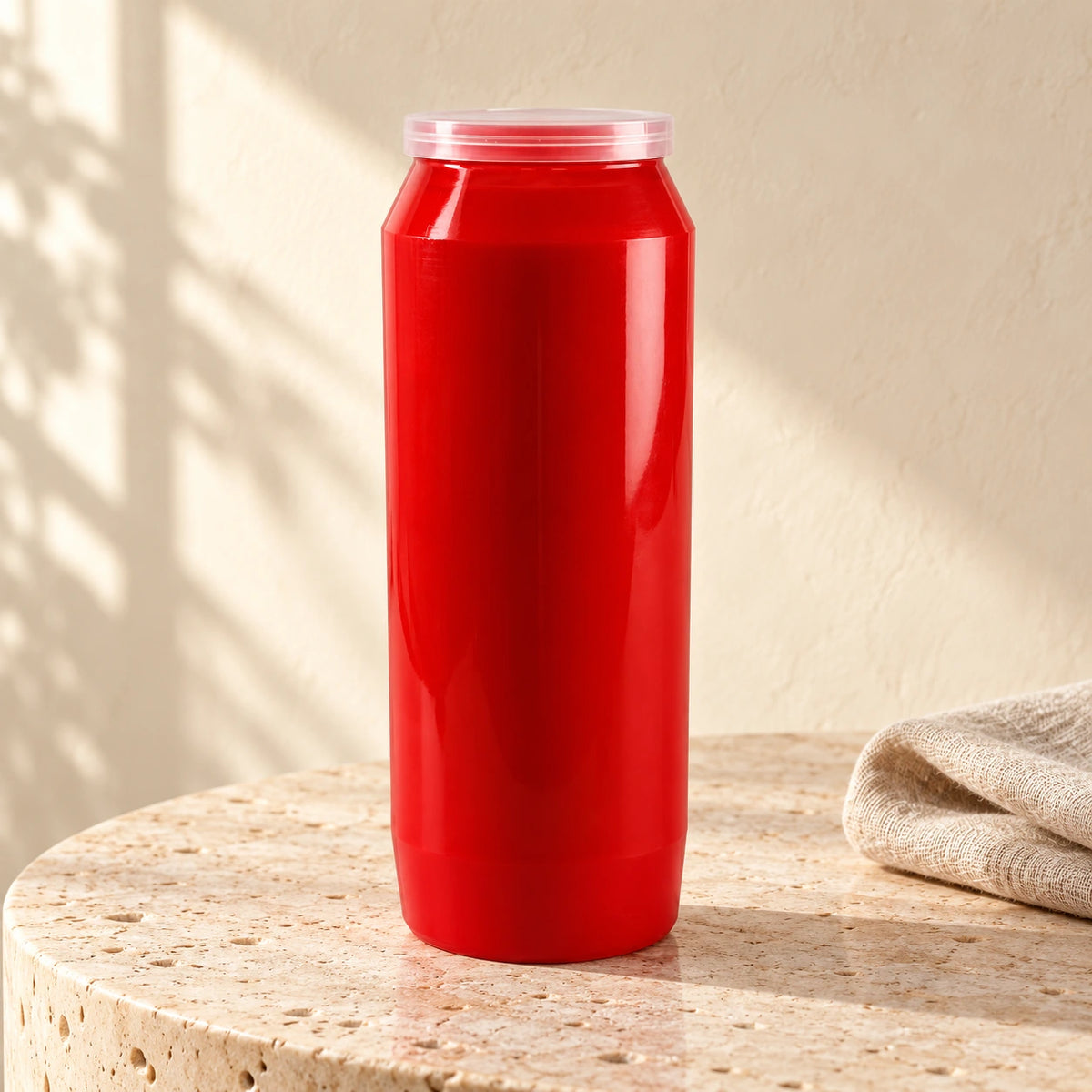 Red CBC 9-day sanctuary candle styled on pale stone with linen