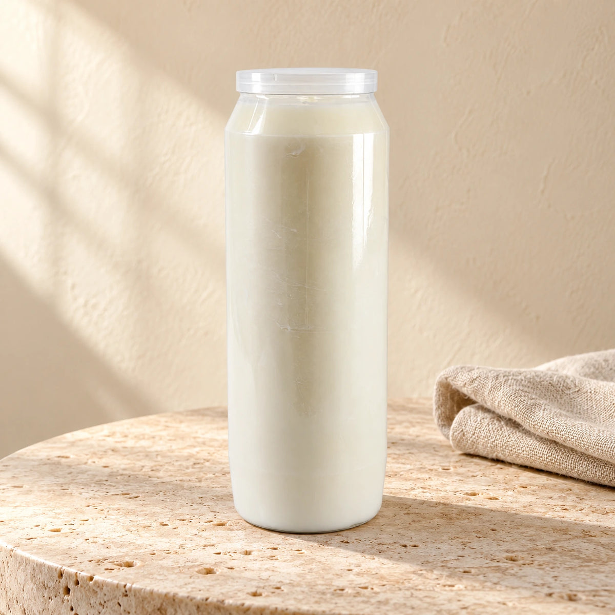 White CBC 9-day sanctuary candle styled on pale stone with linen