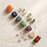 Engraved tumbled gemstone chakra set — Organic Lifestyle Flat Lay | Generated by Modelize